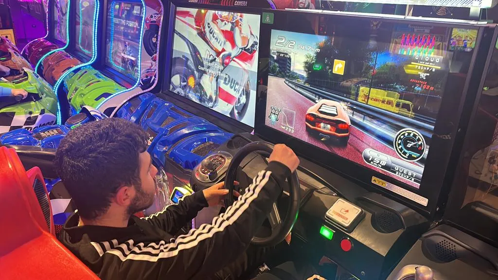 A Focus participant at the wheel of an arcade racing game.