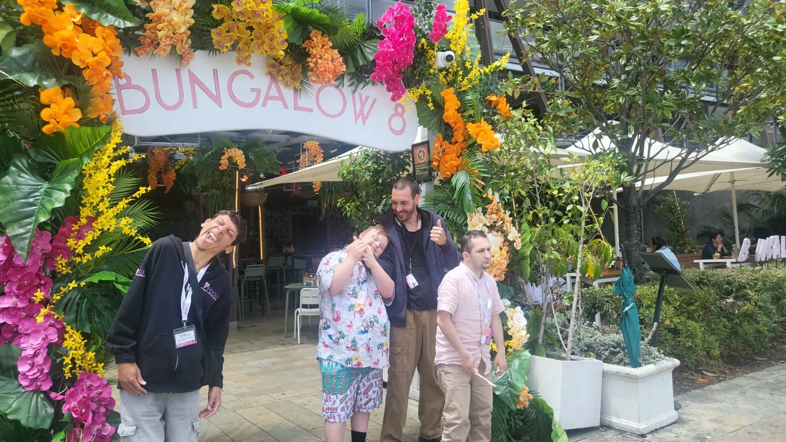 Four members of the Focus community laughing together under a flower archway on a day out in the city.