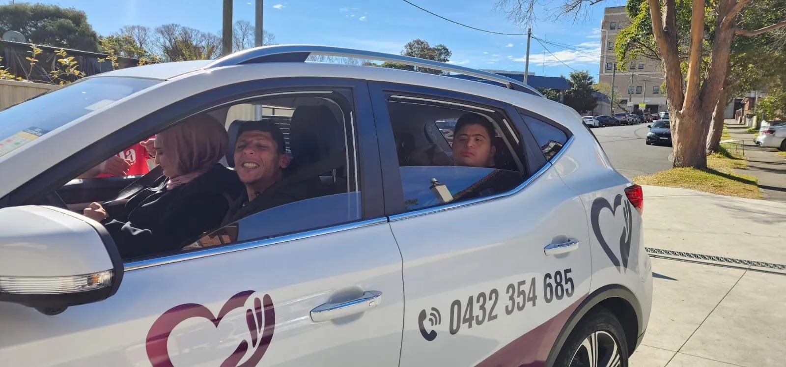 Three people in the Focus branded car heading out for the day, windows down.